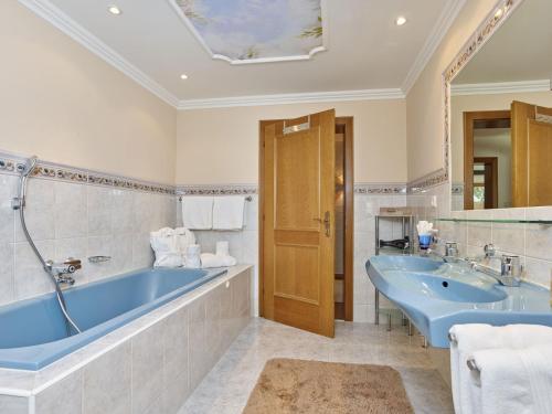 a bathroom with a blue tub and a sink at Apart Helga in Oberlängenfeld
