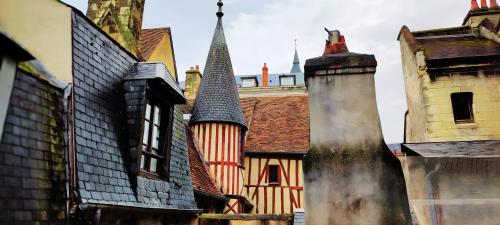 un groupe de bâtiments avec tourelles et toits dans l'établissement 102 Duplex Familial de Charme avec Colombages en Immersion Historique et Confort au Cœur de la Ville, à Bourges
