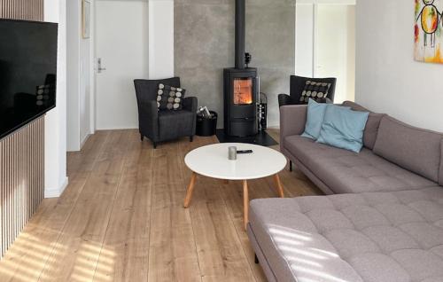 a living room with a couch and a table and a stove at Stunning Home In Sydals With Sauna in Skovbyballe