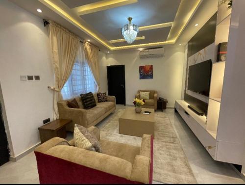 a living room with two couches and a tv at HOMEWORTH SPACES - Shortlet Apartmemt in Alimosho