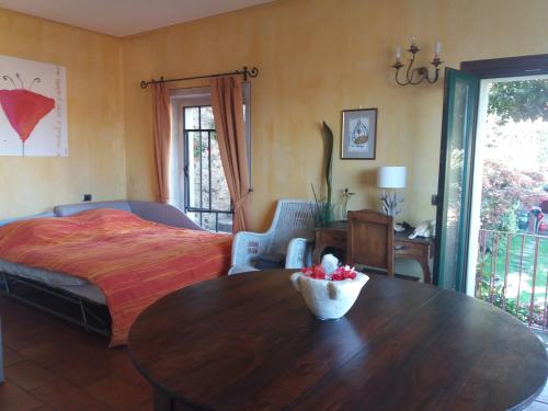 Garden Apartment في لسا: غرفة نوم مع سرير وطاولة مع وعاء من الفواكه عليها