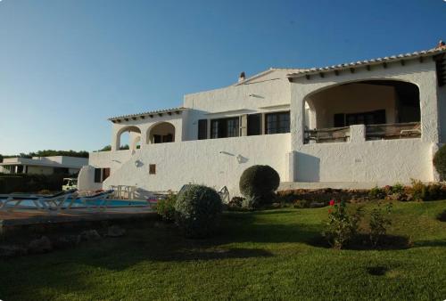 una grande casa bianca con una piscina nel cortile di Binibeca Panorama incredibile a Sant Lluís