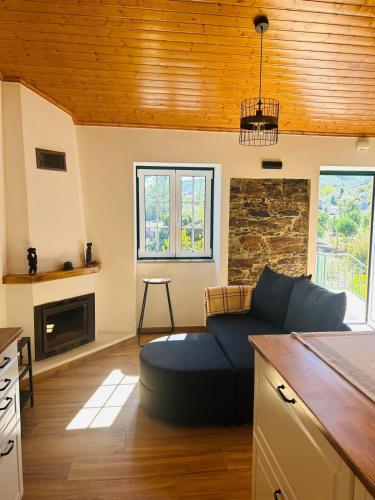 a living room with a blue couch in a kitchen at Casinha da Relva