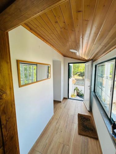 a living room with a wooden ceiling at Casinha da Relva