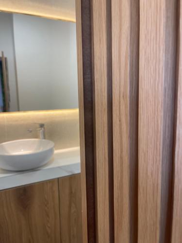 a bathroom with a white sink and a mirror at Vibe Comfort Tirana in Tirana