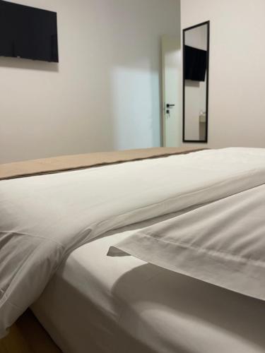 a white bed in a room with a mirror at Vibe Comfort Tirana in Tirana