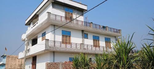 a white building with a balcony on top of it at Nangli Homestay in Meerut