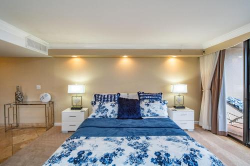 a bedroom with a blue and white bed with two lamps at Kaanapali Shores 942 · KS 942 Spacious Top Floor Studio w Ocean in Kahana