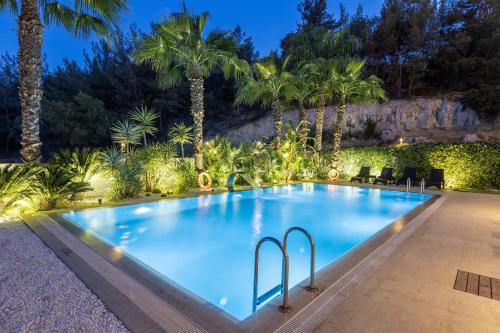 a large swimming pool with palm trees in the background at Utopia Suite Residence1 in Burunabat
