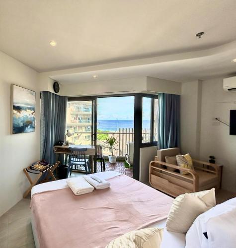 a bedroom with a large bed and a view of the ocean at TDJ Japandi Room with Residential Pool access in Tambuli Seaside Mactan in Maribago