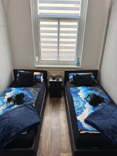 two beds sitting in a room with a window at Apartment Van Gogh in Osterburg Siedlung