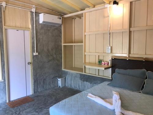 a person laying on a bed in a room at Baan Suan Coconut Ko Yao Noi in Ko Yao Noi