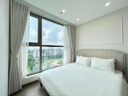 ein Schlafzimmer mit einem weißen Bett und einem großen Fenster in der Unterkunft Licity Cosy Apartment near Old Quarter Hanoi 100m2 in Hanoi