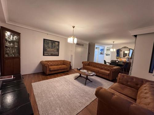 a living room with two couches and a table at Garden Gallery - Tranquil Luxury Retreat in Canberra