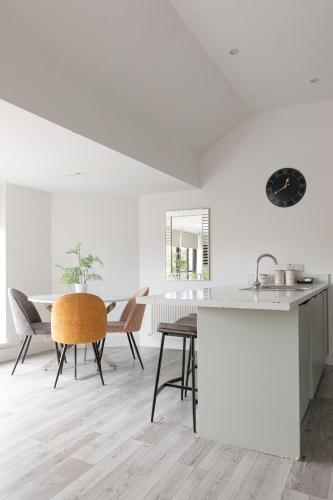 a kitchen and dining room with a table and chairs at Luxury 2BR apartments by Luxus Fully Equipped Kitchen, Ormeau Park in Belfast
