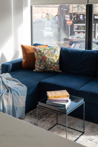 a blue couch with two books on a coffee table at Luxury 2BR apartments by Luxus Fully Equipped Kitchen, Ormeau Park in Belfast