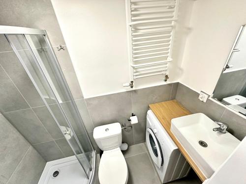 a bathroom with a shower toilet and a sink at leszczynki parter III in Gdynia