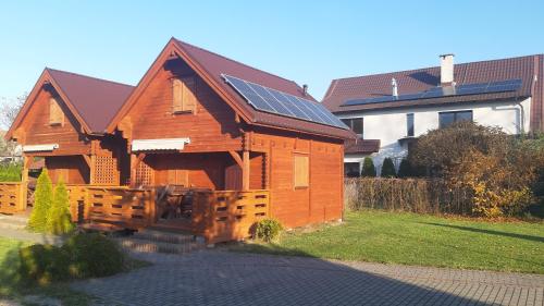 una casa de madera con paneles solares en el techo en Sloneczna 10tka, en Sztutowo