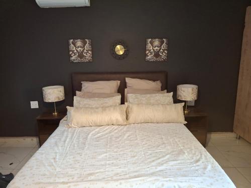 a bedroom with a bed with two lamps and a clock at The Private Location in Thohoyandou