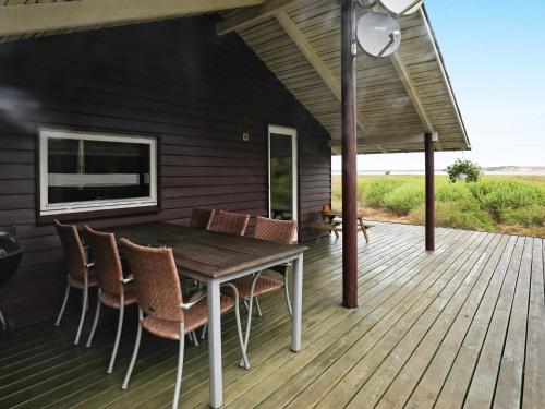 een houten tafel en stoelen op een terras bij 6 person holiday home in Højslev-By Traum in Bøstrup