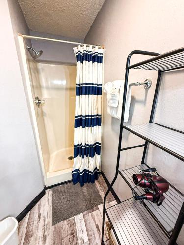 a bathroom with a shower with a shower curtain at Lakefront Home-3BD25BADockGrillFirepitPool in Osage Beach