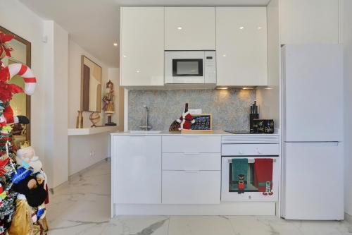 een keuken met witte kasten en een koelkast bij Vaneymar Home in San Miguel de Abona