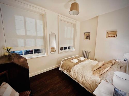 a bedroom with a bed and two windows at Clubhouse, North End, Bedale DL8 1AB in Bedale