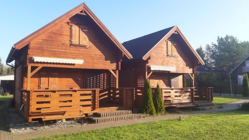 una gran casa de madera con una valla en el patio en Sloneczna 10tka, en Sztutowo