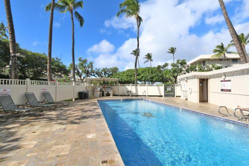 a swimming pool with chairs and palm trees at Kihei Akahi C302 · AKH C302 Spacious 2BD Condo w Ocean Breeze AC in Wailea