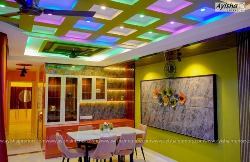 a dining room with a table and chairs and a ceiling with lights at SIS Acropole in Golden Rock