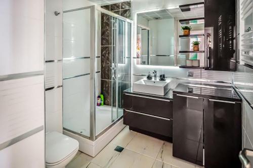a bathroom with a shower and a toilet and a sink at Sky-High 1BR 30 Floor Spa,Gym Cevahir Tower A in Skopje