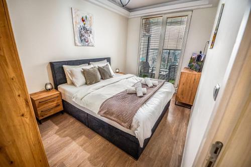 a bedroom with a large bed and a window at Sky-High 1BR 30 Floor Spa,Gym Cevahir Tower A in Skopje