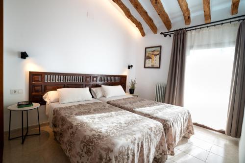ein Schlafzimmer mit zwei Betten und einem Fenster in der Unterkunft LA MUNTANYA - Apartamentos Rural Guadalest in Benimantell