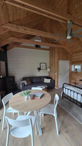 a living room with a table and chairs and a couch at Lodge Klein Ganseij in Olst