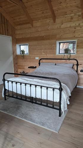 a bedroom with a bed in a wooden cabin at Lodge Klein Ganseij in Olst