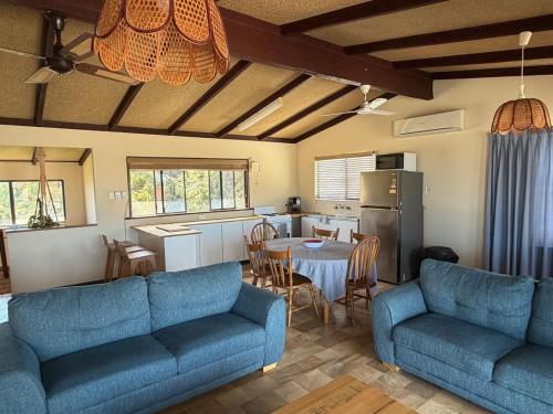 ein Wohnzimmer mit 2 blauen Sofas und einer Küche in der Unterkunft Salt & Sand Stay in Singleton