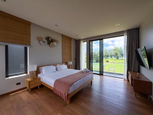 a bedroom with a large bed and a large window at Luxury 3-Bedroom Pool Villa Long One B9 with Panoramic Chalong Bay View in Ban Bo Rae