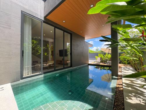 an infinity pool in a villa with a house at Luxury 3-Bedroom Pool Villa Long One B9 with Panoramic Chalong Bay View in Ban Bo Rae