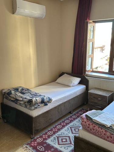 a small bedroom with a bed and a window at ESER PALAS OTELİ in Konya
