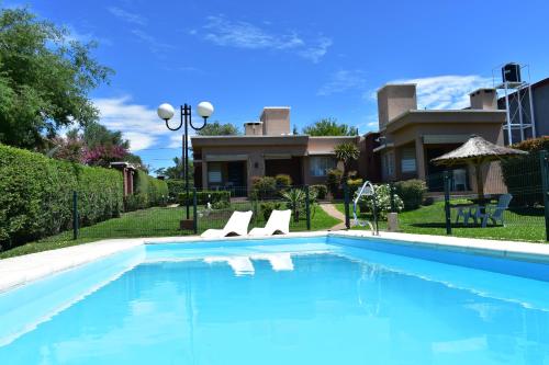 une piscine avec deux chaises et une maison dans l'établissement Aparts Solares, à San Antonio de Arredondo