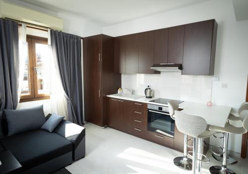 een keuken met een bank en een tafel in een kamer bij Dea Aureum Apartment Limassol in Limassol