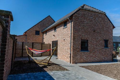 a hammock in front of a brick building at Het Kloosterzicht in Borgloon