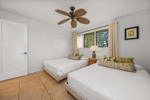 a bedroom with two beds and a ceiling fan at International Colony Club 37 · ICC 37 Remodeled Hawaiian Cottage in Kaanapali