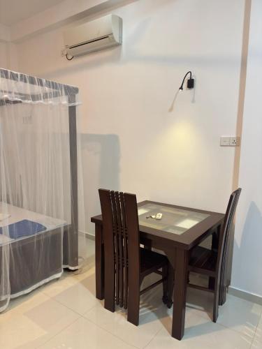a dining room table with two chairs and a lamp at Sun Terra Unawatuna in Unawatuna