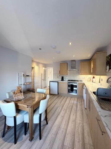 a kitchen and dining room with a wooden table and chairs at River-View Loft, sleeps 4, with parking in Inverness
