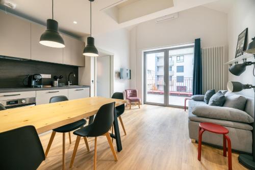 Il dispose d'une cuisine et d'un salon avec une table et des chaises en bois. dans l'établissement Chez Arlette - Neuf - Haut de Gamme - Tram - Proche centre-ville - Tout confort, à Strasbourg