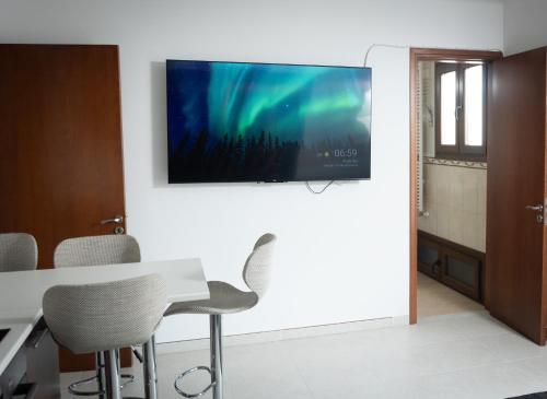 een woonkamer met een tv aan de muur bij Dea Aureum Apartment Limassol in Limassol