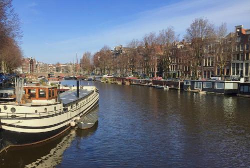 a boat is docked in a canal with buildings at Top-notch space along canal in historic centre in Amsterdam