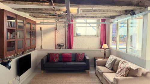 a living room with a couch and a tv at Top-notch space along canal in historic centre in Amsterdam