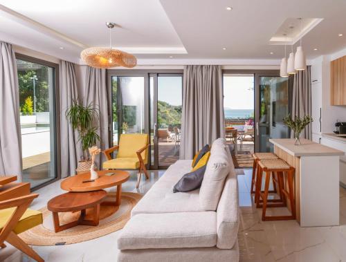 a living room with a couch and a table at Divinum Mare Luxury Villa with Private Pool & Sea View just 200m from the Beach in Palaiochórion